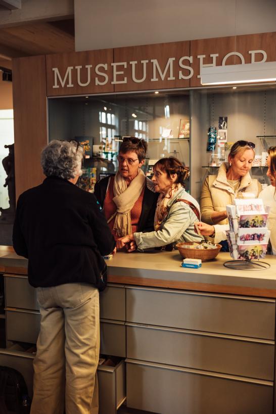 Bezoekers kopen hun ticket aan het onthaal van het museum.